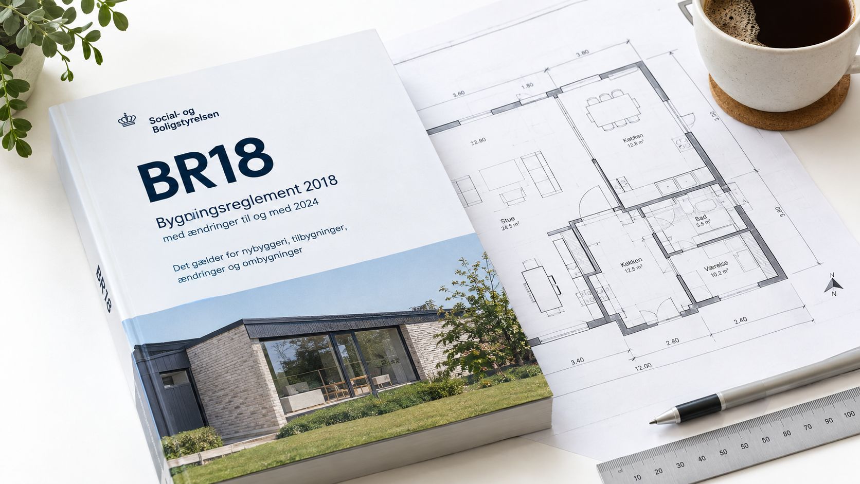 En bog om bygningsreglementet BR18 placeret ved siden af et husdesign på papir med en pen.